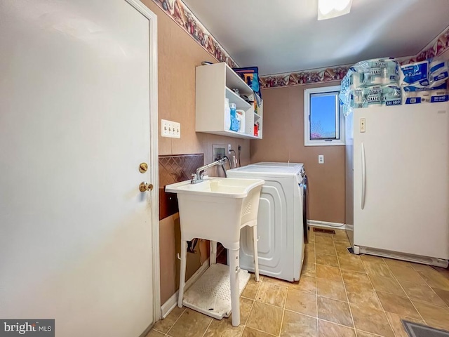 clothes washing area with light tile patterned floors, baseboards, laundry area, and washer and dryer