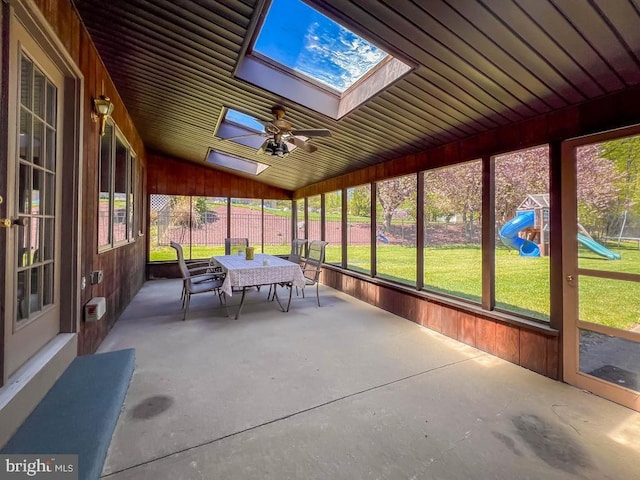 sunroom with a ceiling fan, outdoor dining area, and a skylight