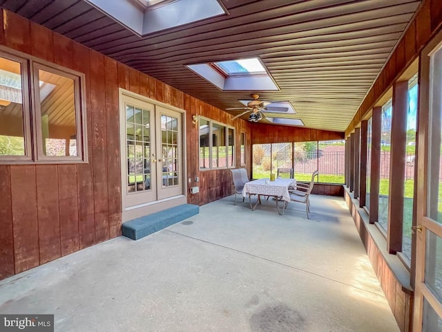 sunroom featuring a skylight, a ceiling fan, and french doors