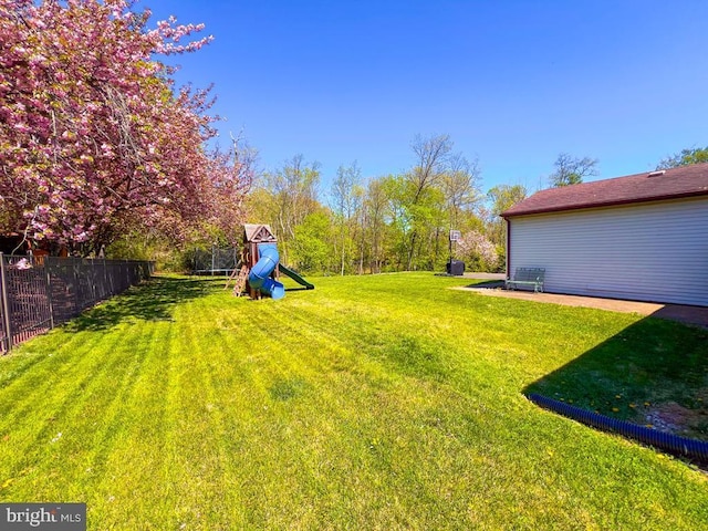 view of yard featuring a playground and fence