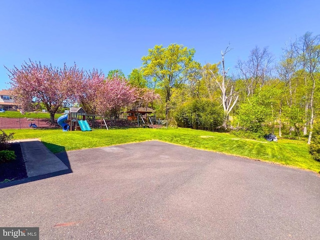 view of patio with a playground and fence