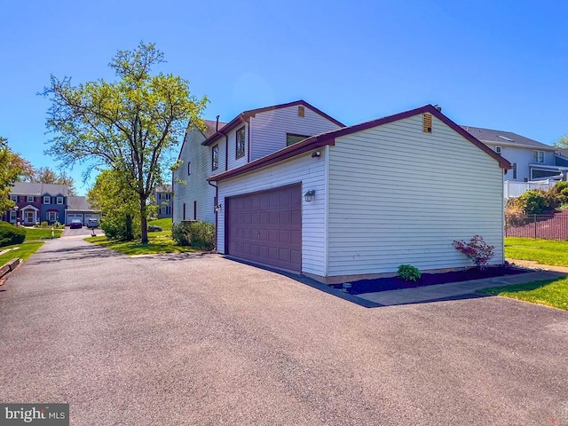 view of home's exterior with an attached garage, driveway, and a residential view