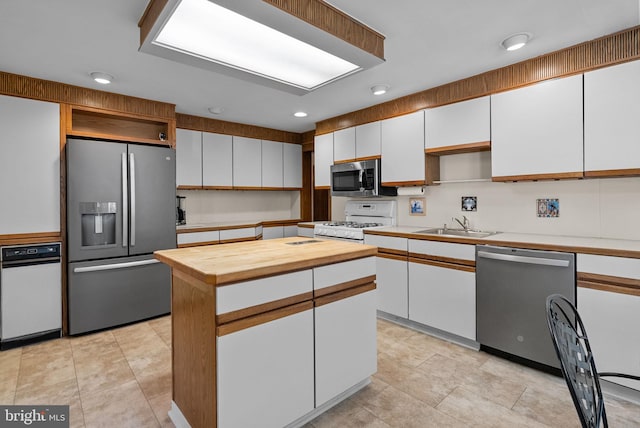 kitchen featuring white cabinets, stainless steel appliances, open shelves, and wooden counters