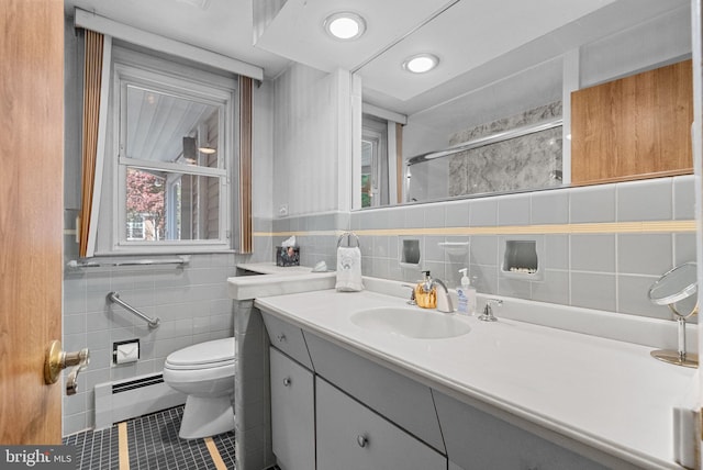 bathroom featuring tile patterned flooring, vanity, toilet, tile walls, and baseboard heating