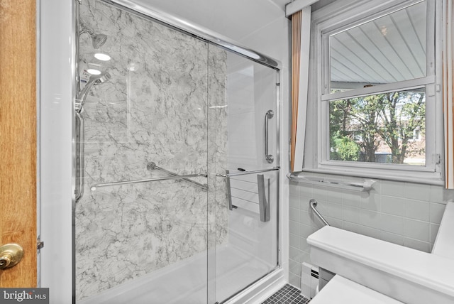 bathroom with tile patterned flooring, a stall shower, and toilet