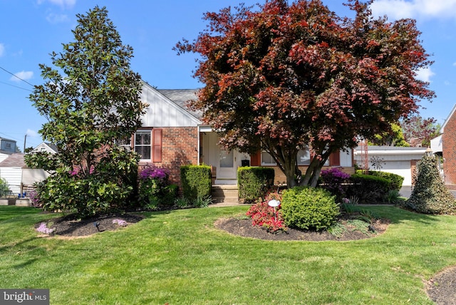obstructed view of property featuring brick siding, a garage, and a front lawn