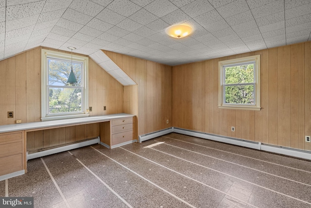 bonus room featuring wooden walls, a baseboard radiator, and a wealth of natural light