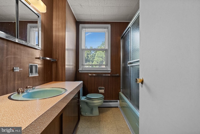full bathroom featuring wood walls, toilet, baseboard heating, tile patterned floors, and enclosed tub / shower combo