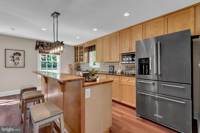 302 Maple Ln, Severna Park, MD 21146 - kitchen with appliances with stainless steel finishes, wooden counters, light wood-style flooring, light brown cabinetry, and tasteful backsplash