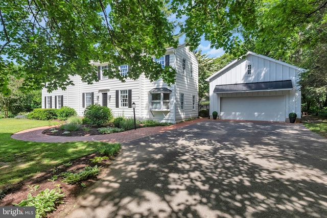 302 Maple Ln, Severna Park, MD 21146 - view of front of property featuring driveway, an outdoor structure, board and batten siding, a garage, and a front lawn