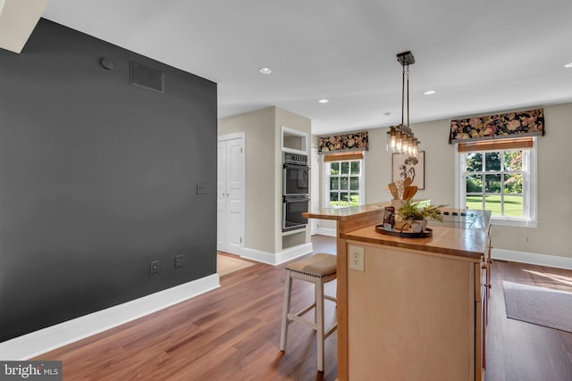 302 Maple Ln, Severna Park, MD 21146 - kitchen with wood finished floors, baseboards, a kitchen bar, a kitchen island, and butcher block countertops