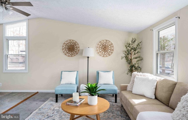 carpeted living room with a ceiling fan, a textured ceiling, a healthy amount of sunlight, and vaulted ceiling