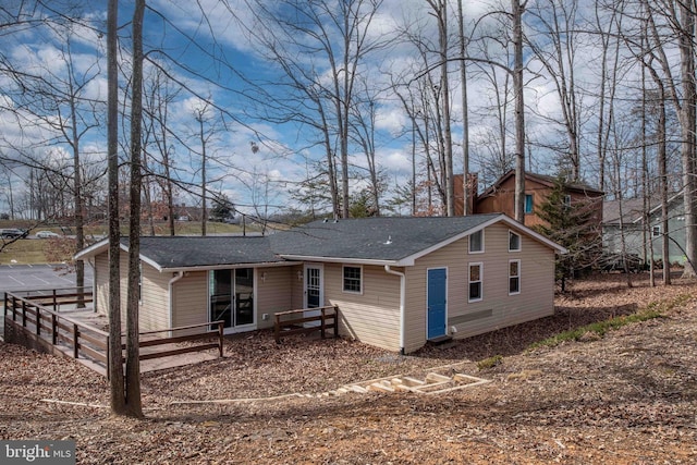 view of front of home featuring fence and roof with shingles