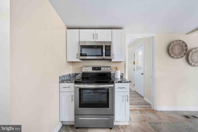 kitchen featuring white cabinetry, baseboards, appliances with stainless steel finishes, and visible vents