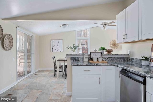 kitchen with stainless steel dishwasher, white cabinetry, baseboards, and dark stone counters