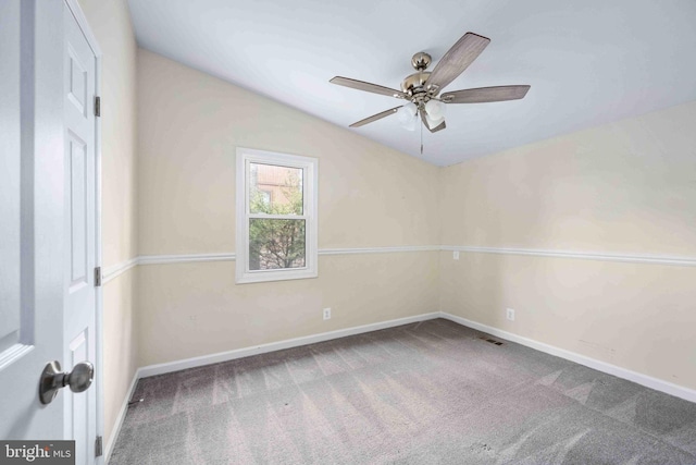 carpeted empty room featuring baseboards, ceiling fan, and visible vents
