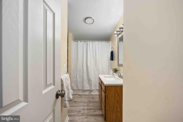 full bath with a shower with curtain, wood finished floors, and vanity