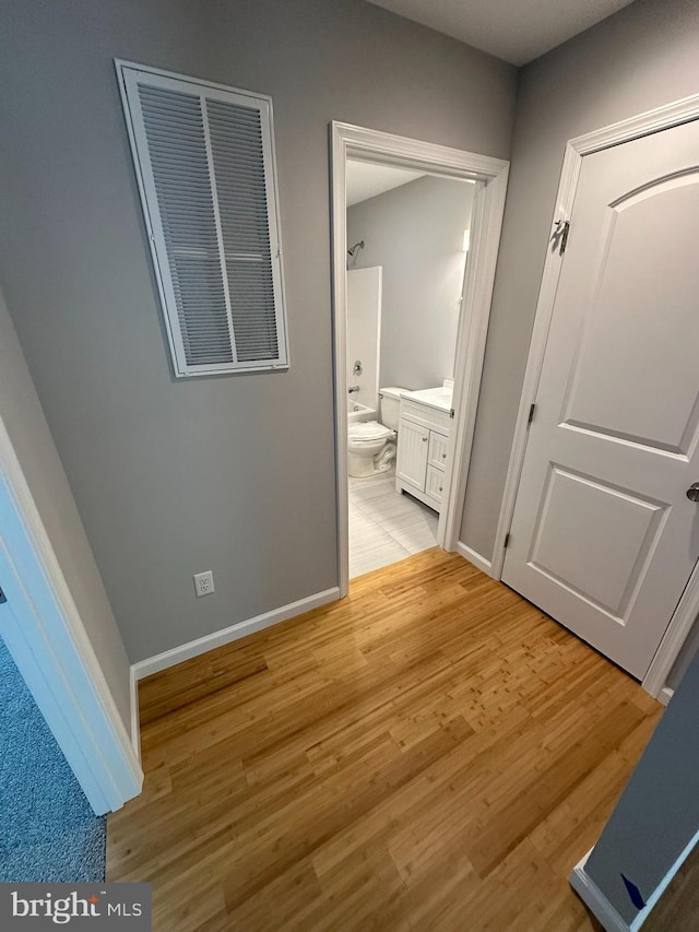 hall with baseboards and light wood-type flooring