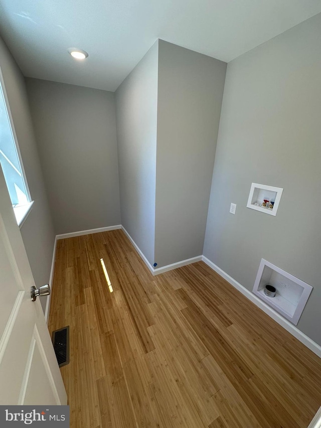 laundry area featuring baseboards, light wood finished floors, hookup for a washing machine, and visible vents