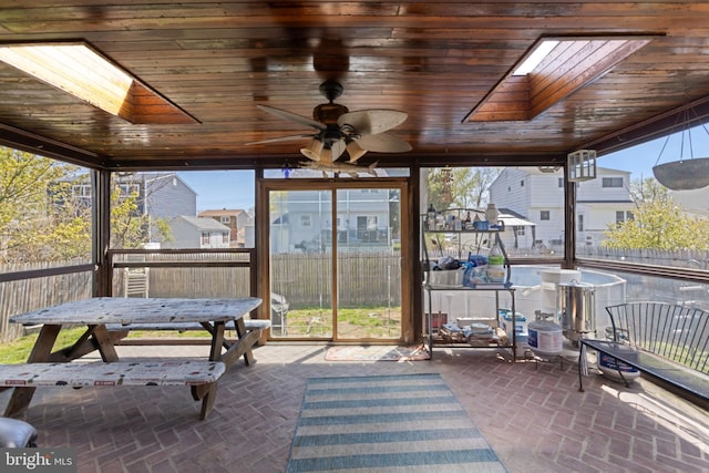 sunroom / solarium with ceiling fan and a skylight