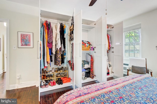 bedroom featuring a ceiling fan, wood finished floors, baseboards, a closet, and radiator heating unit
