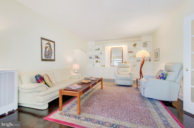 living area with built in shelves and wood finished floors