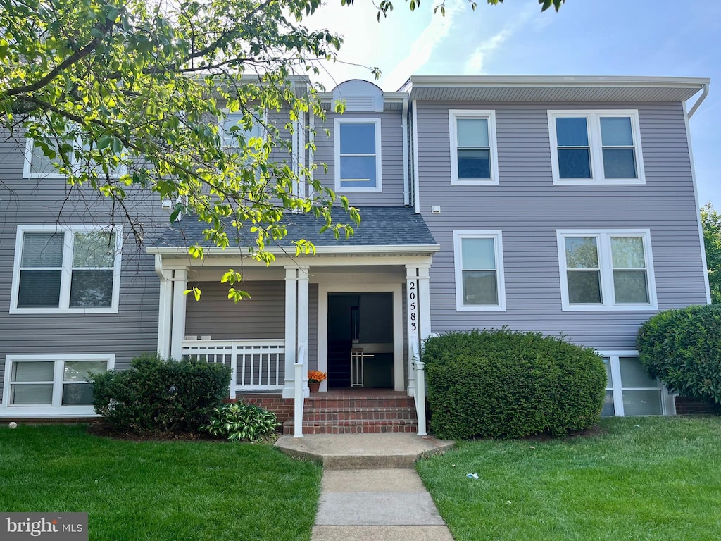townhome / multi-family property featuring a porch and a front lawn