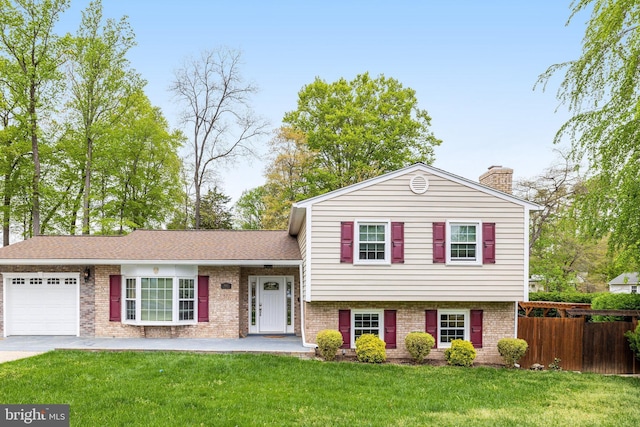 8610 Westmeath Ct, Springfield, VA 22152 - tri-level home featuring fence, an attached garage, a front lawn, brick siding, and a chimney