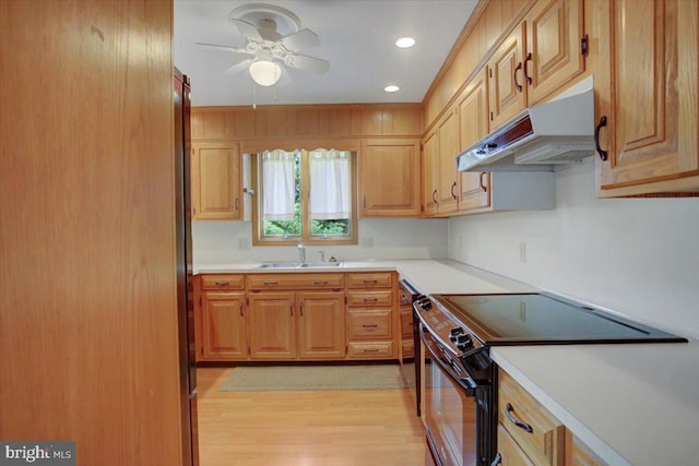 kitchen featuring a ceiling fan, electric range, light wood-type flooring, a sink, and under cabinet range hood