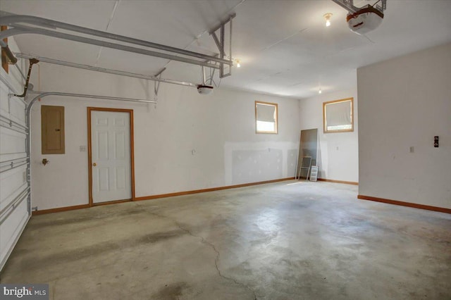 garage with baseboards, a garage door opener, and electric panel