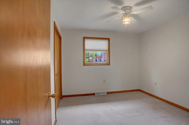 spare room with baseboards, carpet, a ceiling fan, and visible vents