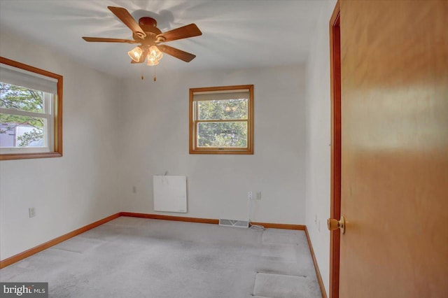 empty room featuring carpet floors, baseboards, visible vents, and ceiling fan