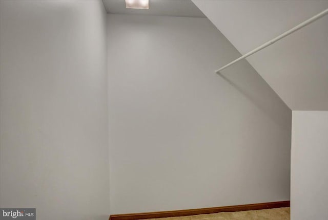walk in closet featuring light carpet and vaulted ceiling
