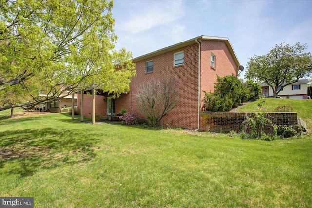 exterior space featuring brick siding and a lawn