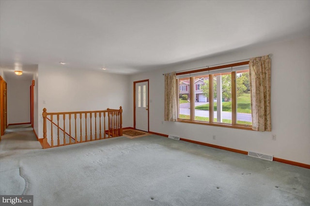 carpeted empty room with visible vents and baseboards