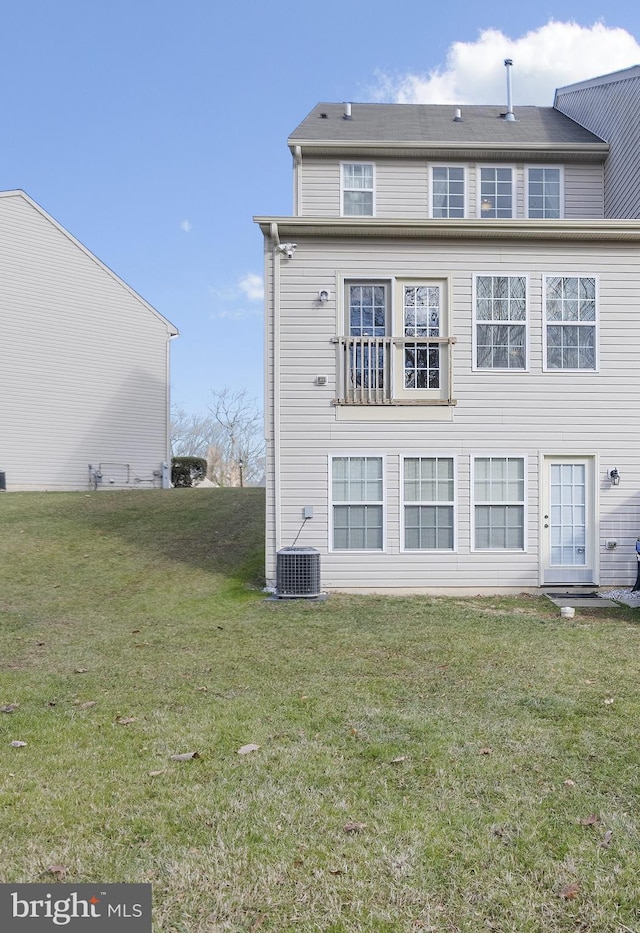 back of property featuring a yard and central air condition unit