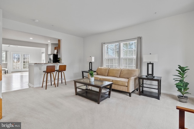 living area with baseboards, light colored carpet, recessed lighting, and a wealth of natural light