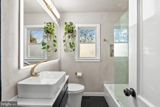 full bathroom with tile patterned flooring, a bathing tub, baseboards, vanity, and toilet