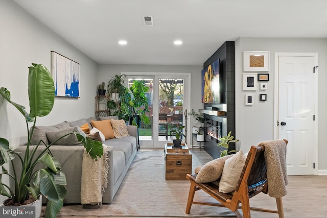 living room featuring visible vents, recessed lighting, light wood-style flooring, and a fireplace