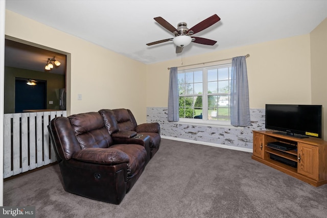 carpeted living room featuring baseboards and a ceiling fan