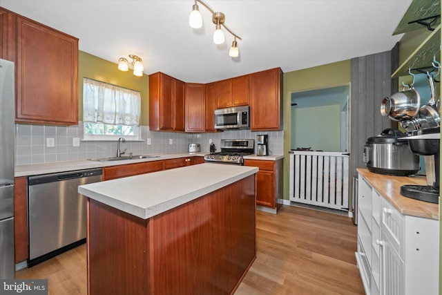 kitchen featuring a sink, appliances with stainless steel finishes, decorative backsplash, and light countertops