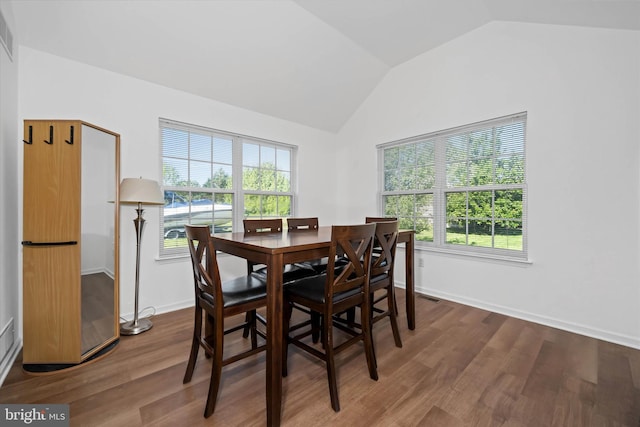 dining room with baseboards, wood finished floors, and vaulted ceiling