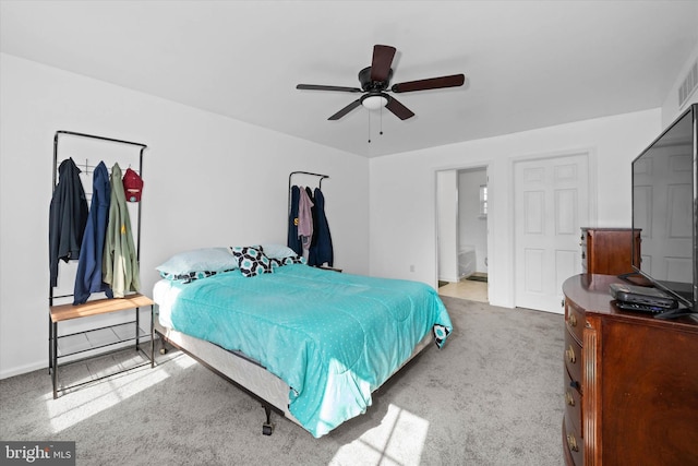 carpeted bedroom with connected bathroom, a ceiling fan, and baseboards