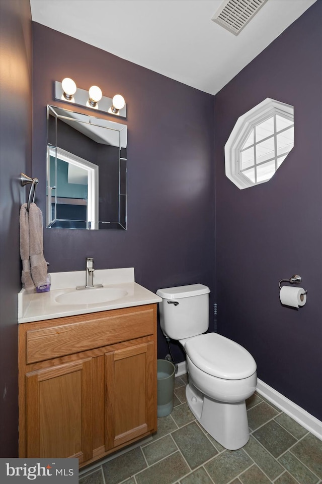 bathroom featuring visible vents, tile patterned flooring, vanity, baseboards, and toilet