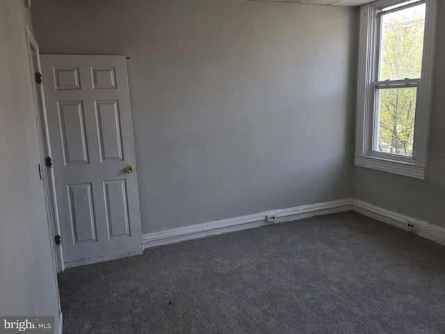 unfurnished room with carpet flooring, baseboards, and plenty of natural light