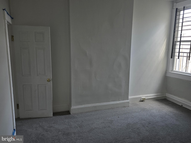 unfurnished room featuring carpet floors and baseboards