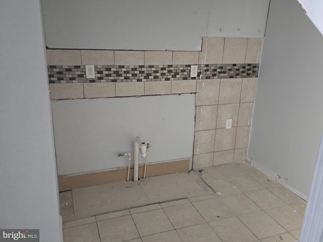 clothes washing area featuring light tile patterned floors