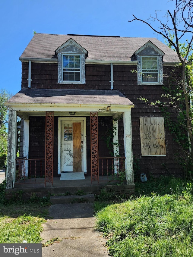 view of front of property featuring covered porch and a shingled roof