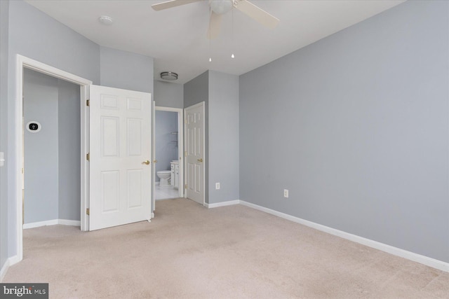 unfurnished bedroom with baseboards, ceiling fan, light carpet, and connected bathroom