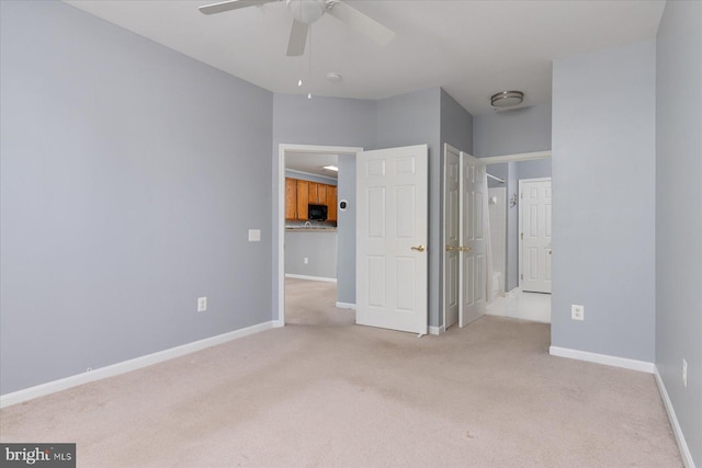 unfurnished bedroom featuring baseboards, a ceiling fan, and light carpet